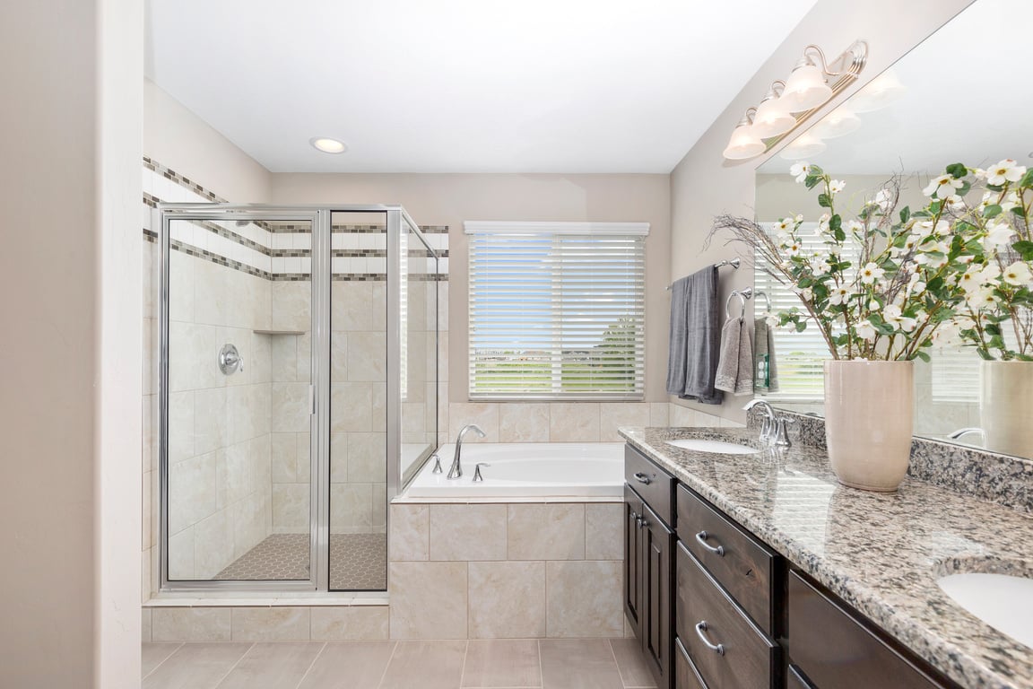 Gorgeous bathroom with dark cabinetry amidst white surroundings